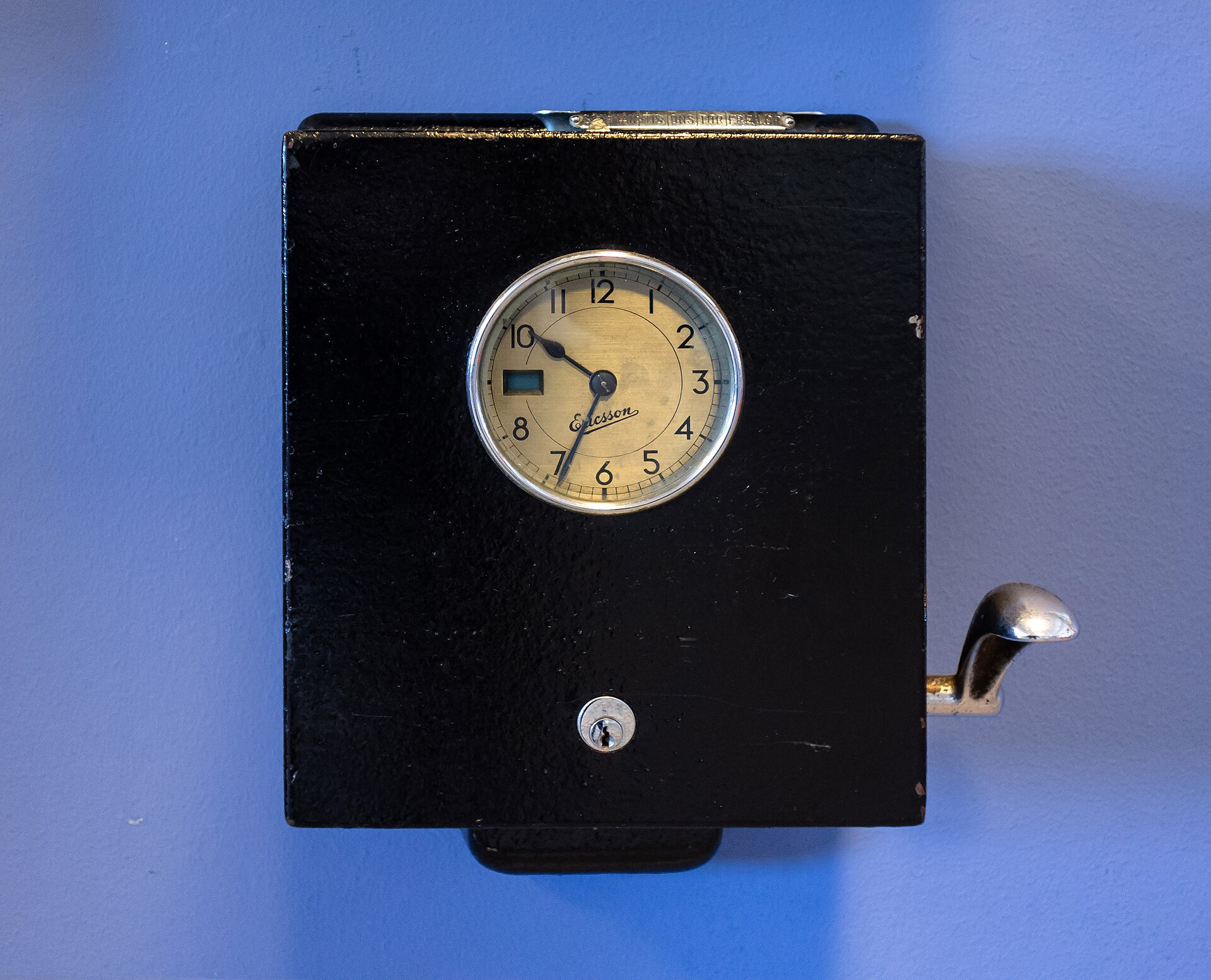 An old LM Ericsson punch clock mounted on a wall